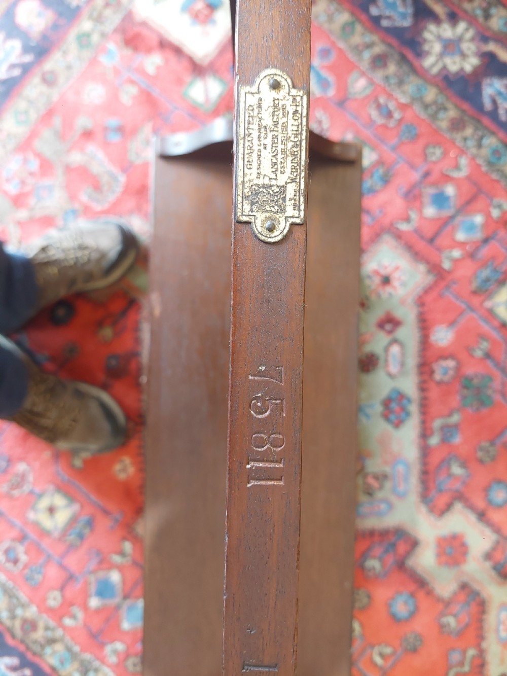 An Edwardian mahogany two-tier standing book trough featuring a shaped top apron, middle shelf, carved stretcher, and splayed legs. View VIII