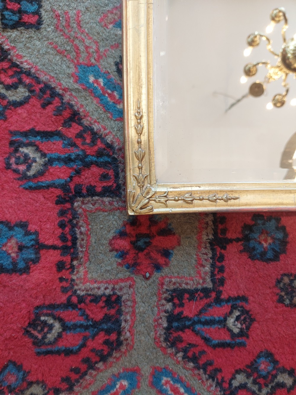 A 19th-century rectangular giltwood overmantel mirror with rounded top corners and subtle leaf moulding details along the gold frame. View III