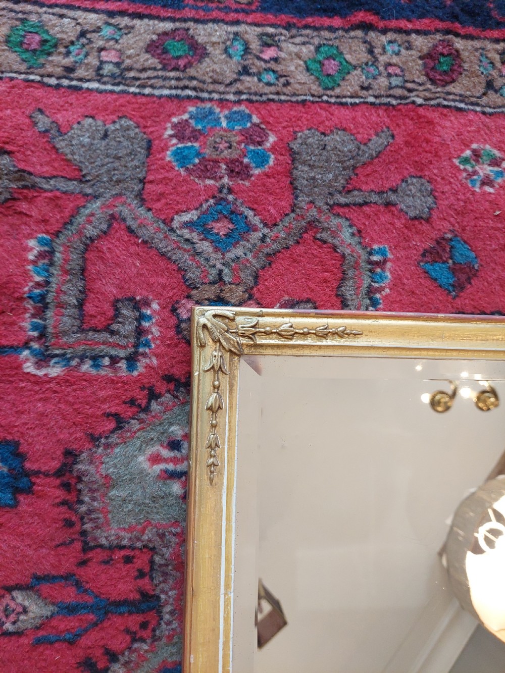 A 19th-century rectangular giltwood overmantel mirror with rounded top corners and subtle leaf moulding details along the gold frame. View V