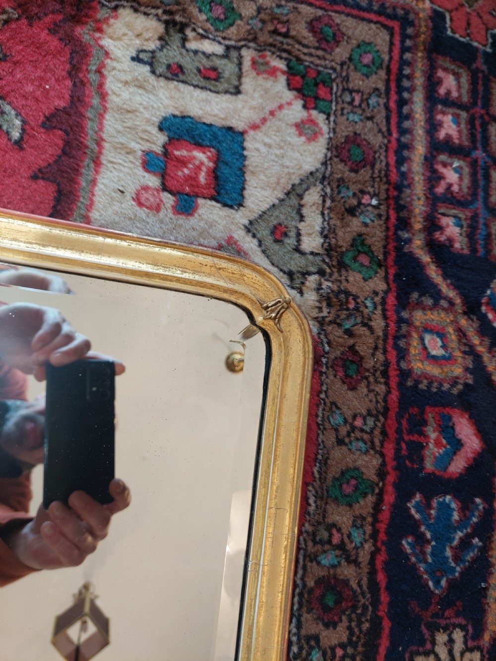 A 19th-century rectangular giltwood overmantel mirror with rounded top corners and subtle leaf moulding details along the gold frame. View VI
