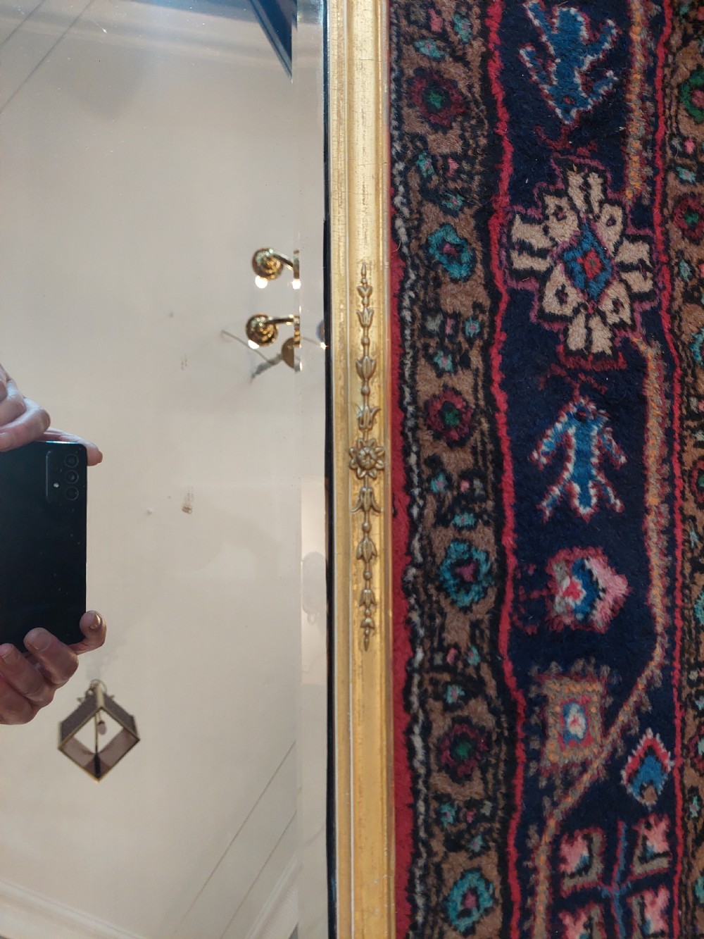 A 19th-century rectangular giltwood overmantel mirror with rounded top corners and subtle leaf moulding details along the gold frame. View VII