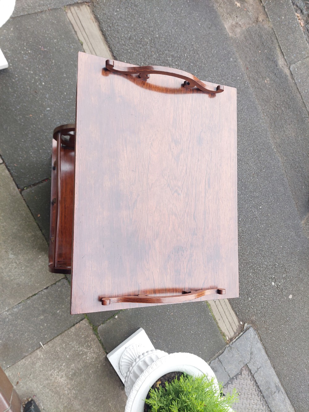 A Victorian rosewood Canterbury whatnot featuring a top shelf supported by pierced fretwork side panels, slatted sheet music partitions, a lower drawer, and turned legs with brass castors. View II