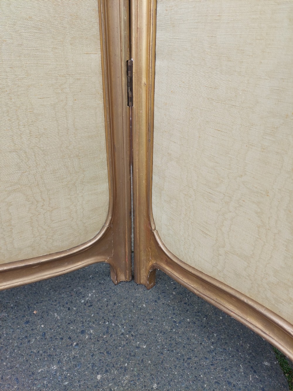 A mid-19th century three-panel giltwood vanity screen featuring carved Rococo cresting, clear glass top panels, and cream upholstered lower panels. View V