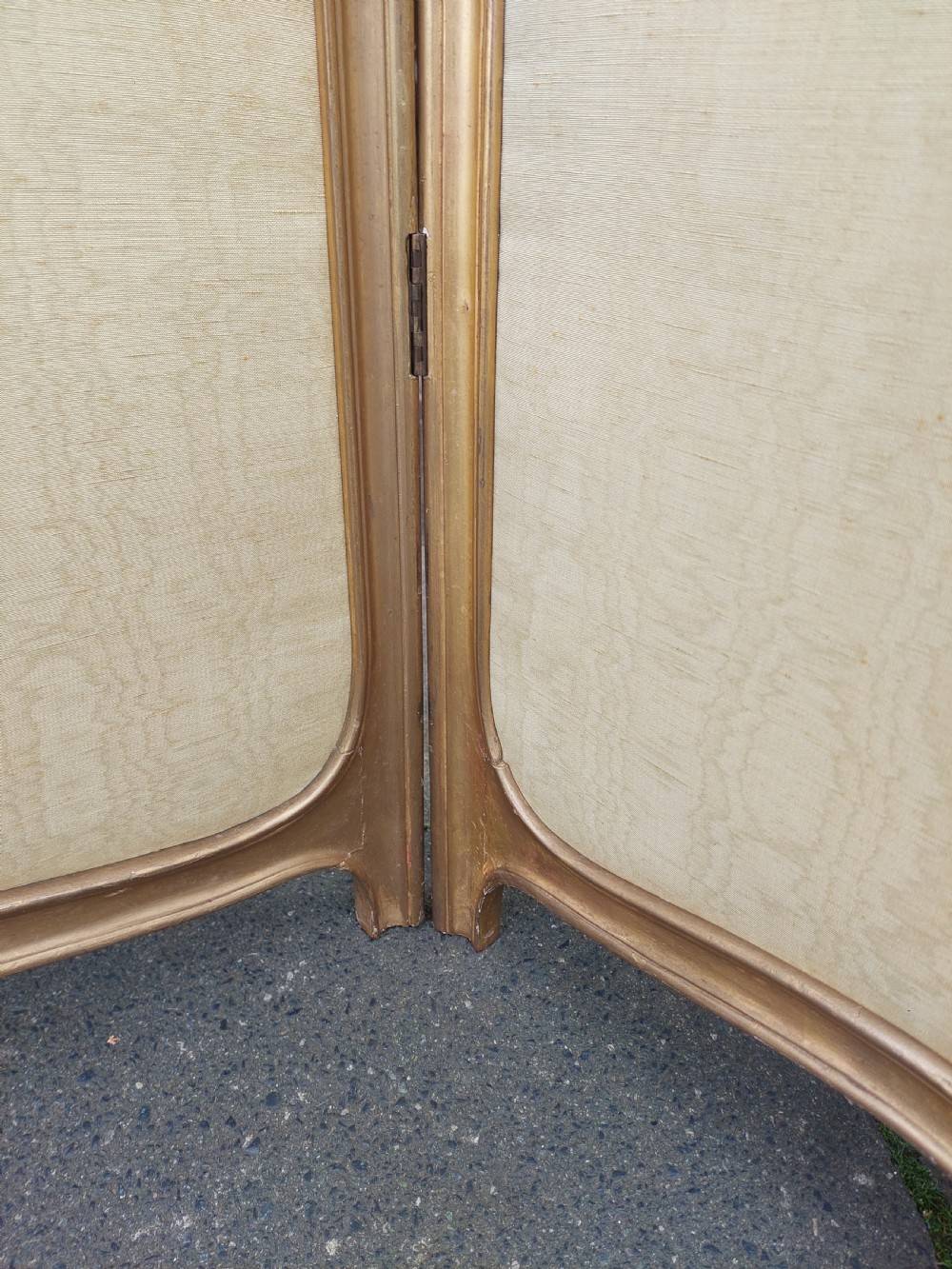 A mid-19th century three-panel giltwood vanity screen featuring carved Rococo cresting, clear glass top panels, and cream upholstered lower panels. View VI