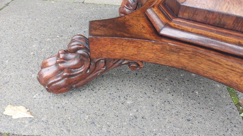 A 19th-century William IV rosewood fold-over card table supported on a central tapered pedestal and a quadruped base with carved scroll feet. View II