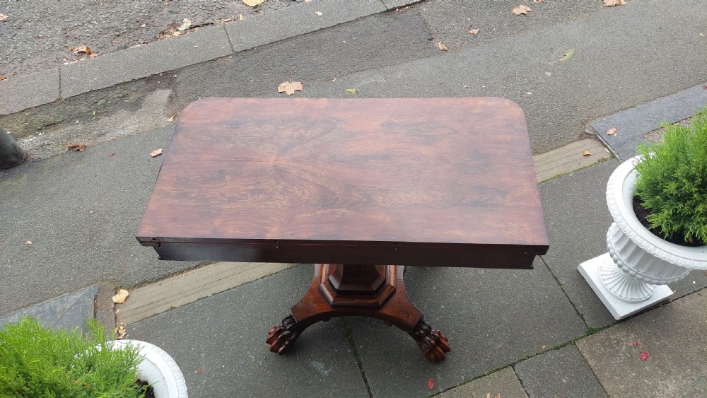 A 19th-century William IV rosewood fold-over card table supported on a central tapered pedestal and a quadruped base with carved scroll feet. View III