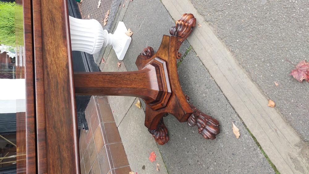 A 19th-century William IV rosewood fold-over card table supported on a central tapered pedestal and a quadruped base with carved scroll feet. View V