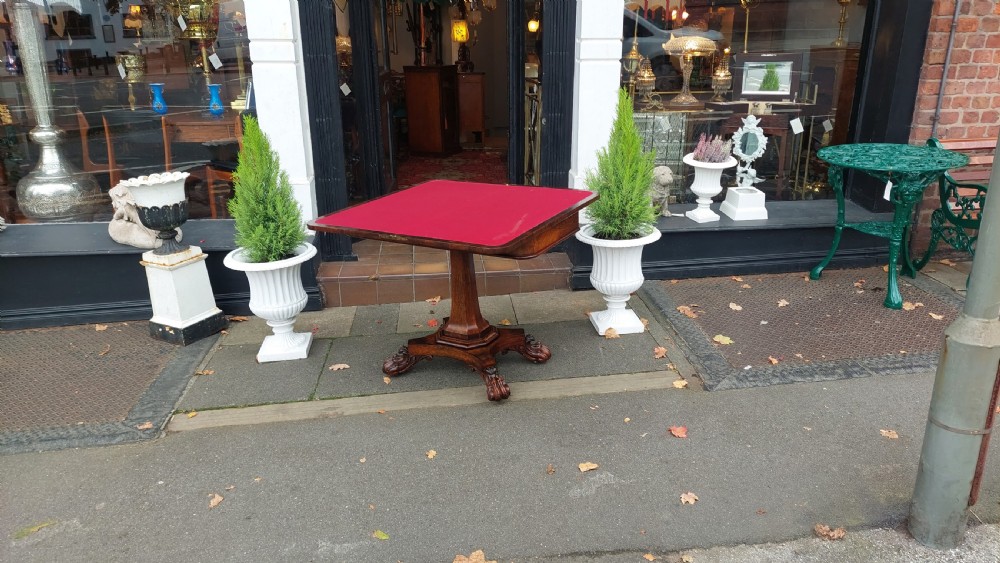 A 19th-century William IV rosewood fold-over card table supported on a central tapered pedestal and a quadruped base with carved scroll feet. View VIII