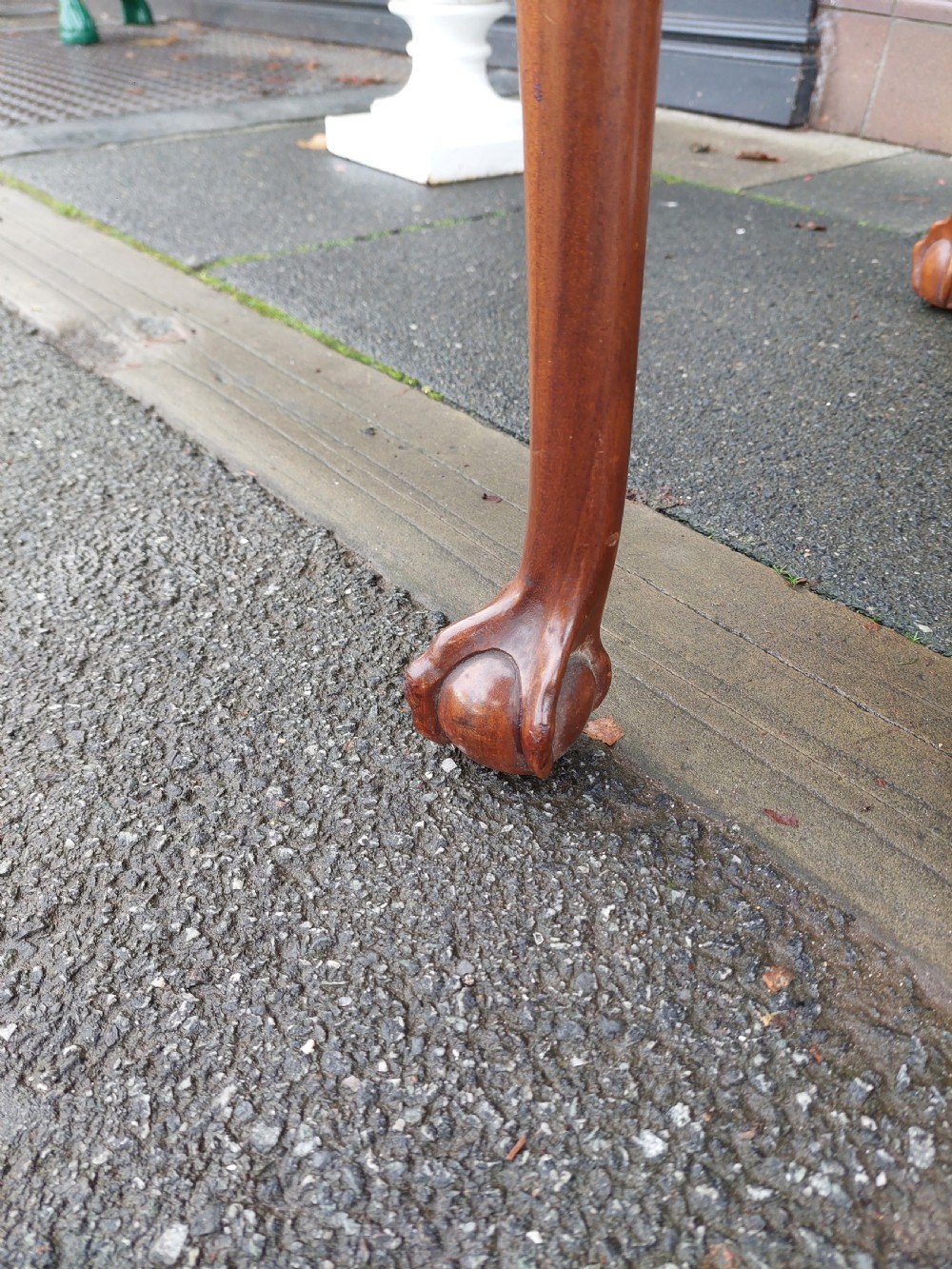 A semi-circular walnut fold-over card table with figured veneer top, carved apron, cabriole legs, and ball and claw feet. View V