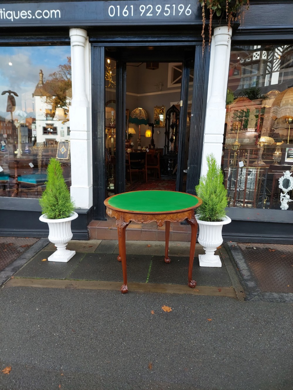 A semi-circular walnut fold-over card table with figured veneer top, carved apron, cabriole legs, and ball and claw feet. View IX