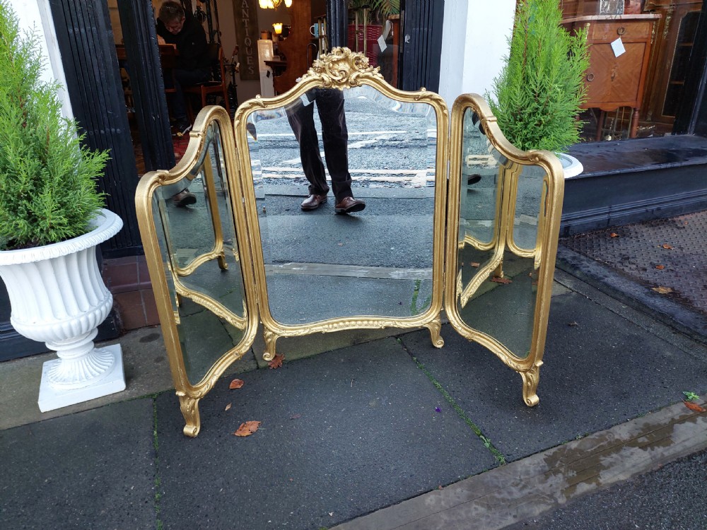 A three-panel folding triptych dressing table mirror featuring a gilded frame with Rococo carved cresting and bevelled glass. View III