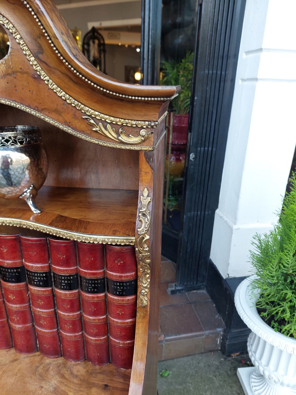 A nineteenth-century French walnut open bookcase featuring serpentine tiers and gilded bronze mounts. View V