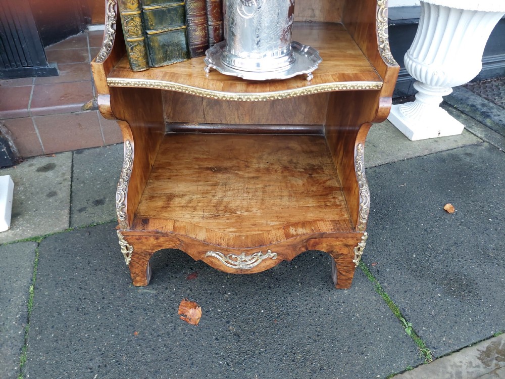 A nineteenth-century French walnut open bookcase featuring serpentine tiers and gilded bronze mounts. View X