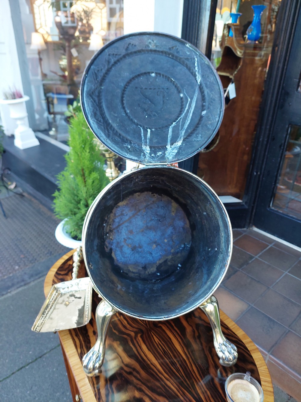 A Victorian silver-plated barrel-shaped coal scuttle resting on three claw feet with an engraved crest and attached scoop. View III