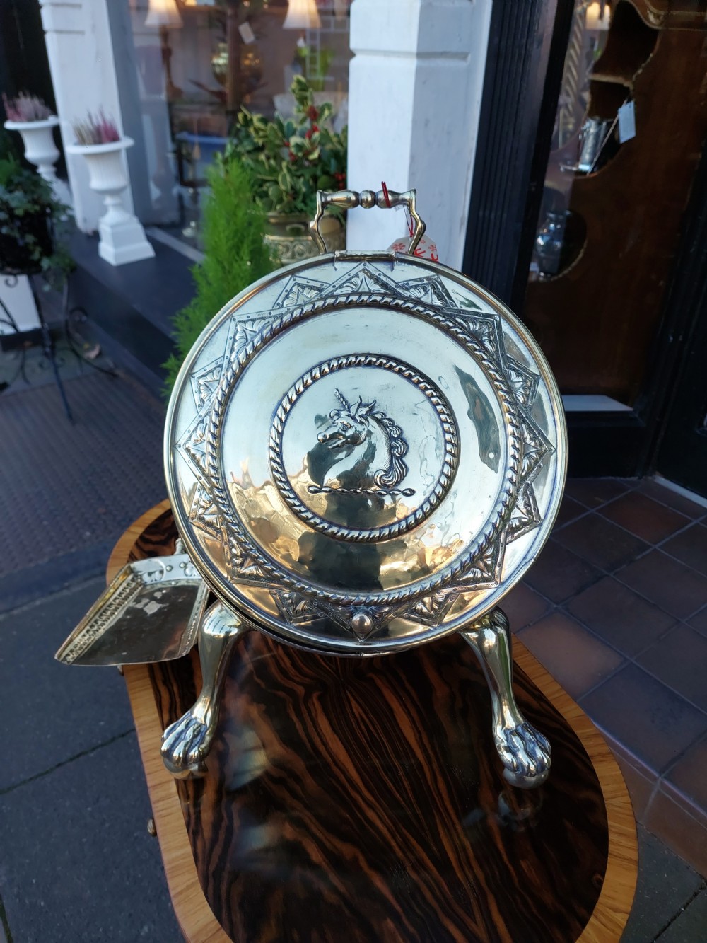 A Victorian silver-plated barrel-shaped coal scuttle resting on three claw feet with an engraved crest and attached scoop. View VI