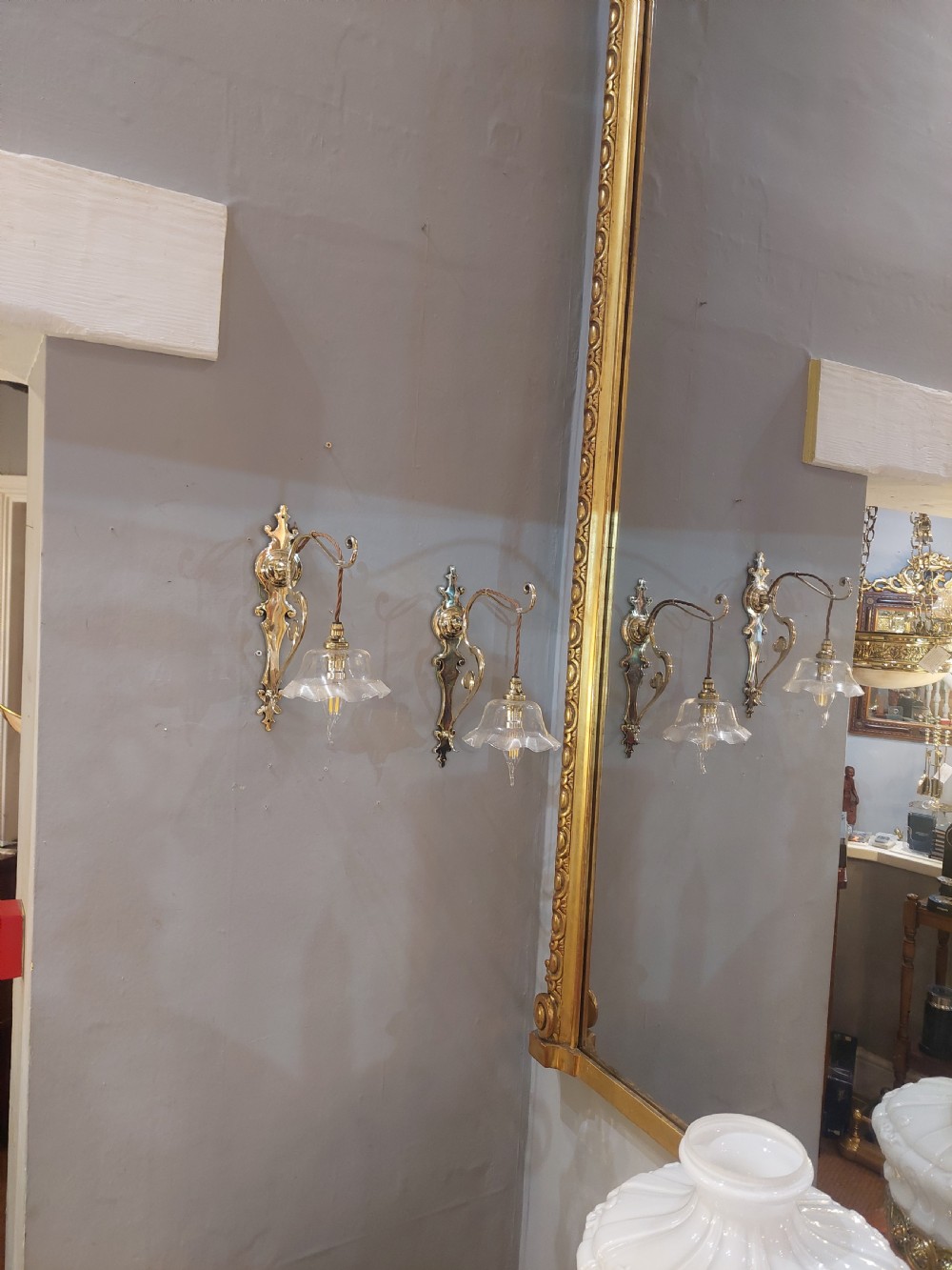 A pair of polished brass Art Nouveau wall sconces featuring decorative backplates, gooseneck arms, twisted flex, and ruffled clear glass shades. View II