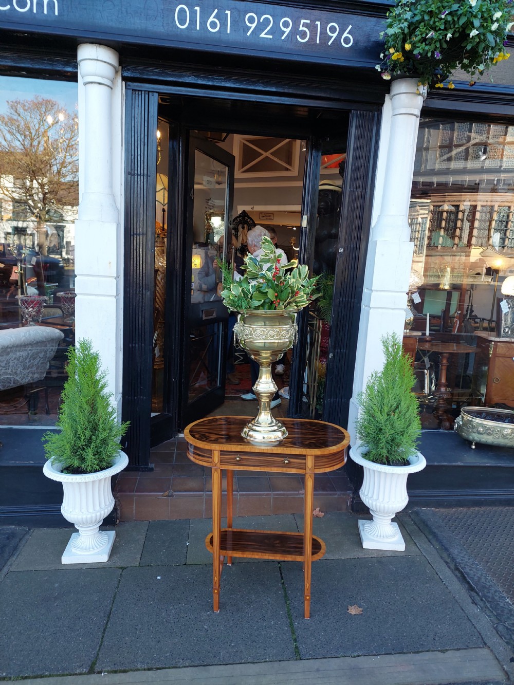 A polished late nineteenth-century pressed brass urn planter positioned on a turned pedestal base. View II