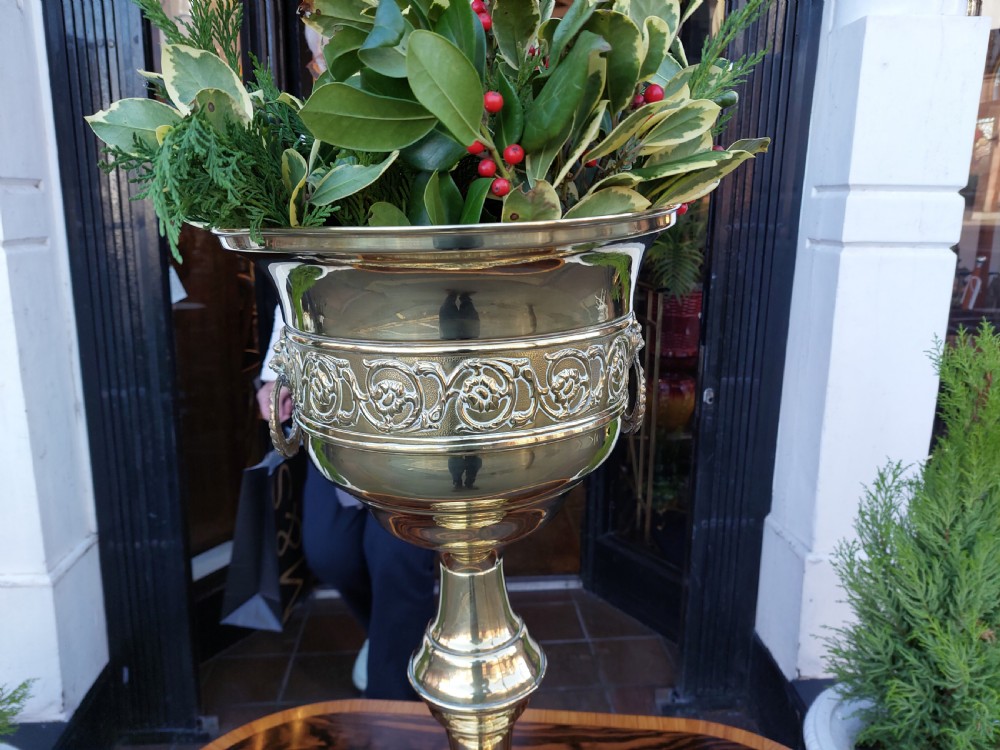 A polished late nineteenth-century pressed brass urn planter positioned on a turned pedestal base. View III
