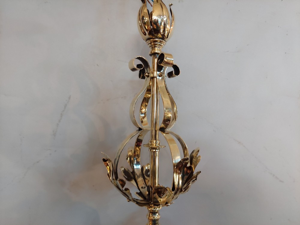 An Art Nouveau ceiling pendant light featuring polished brass scrollwork and leaf detailing suspending a swirled pale green glass globe shade. View V