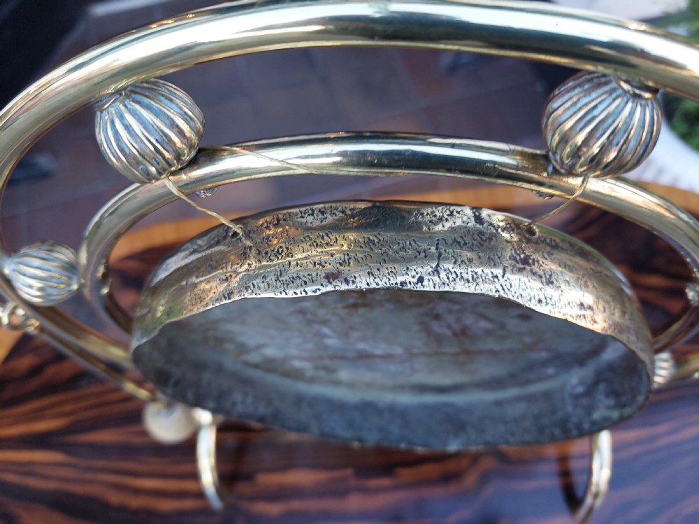 A late 19th-century polished metal tabletop gong with a circular hammered centre plate, ribbed decorative beads, a framed stand, and an attached hanging striker. View VII