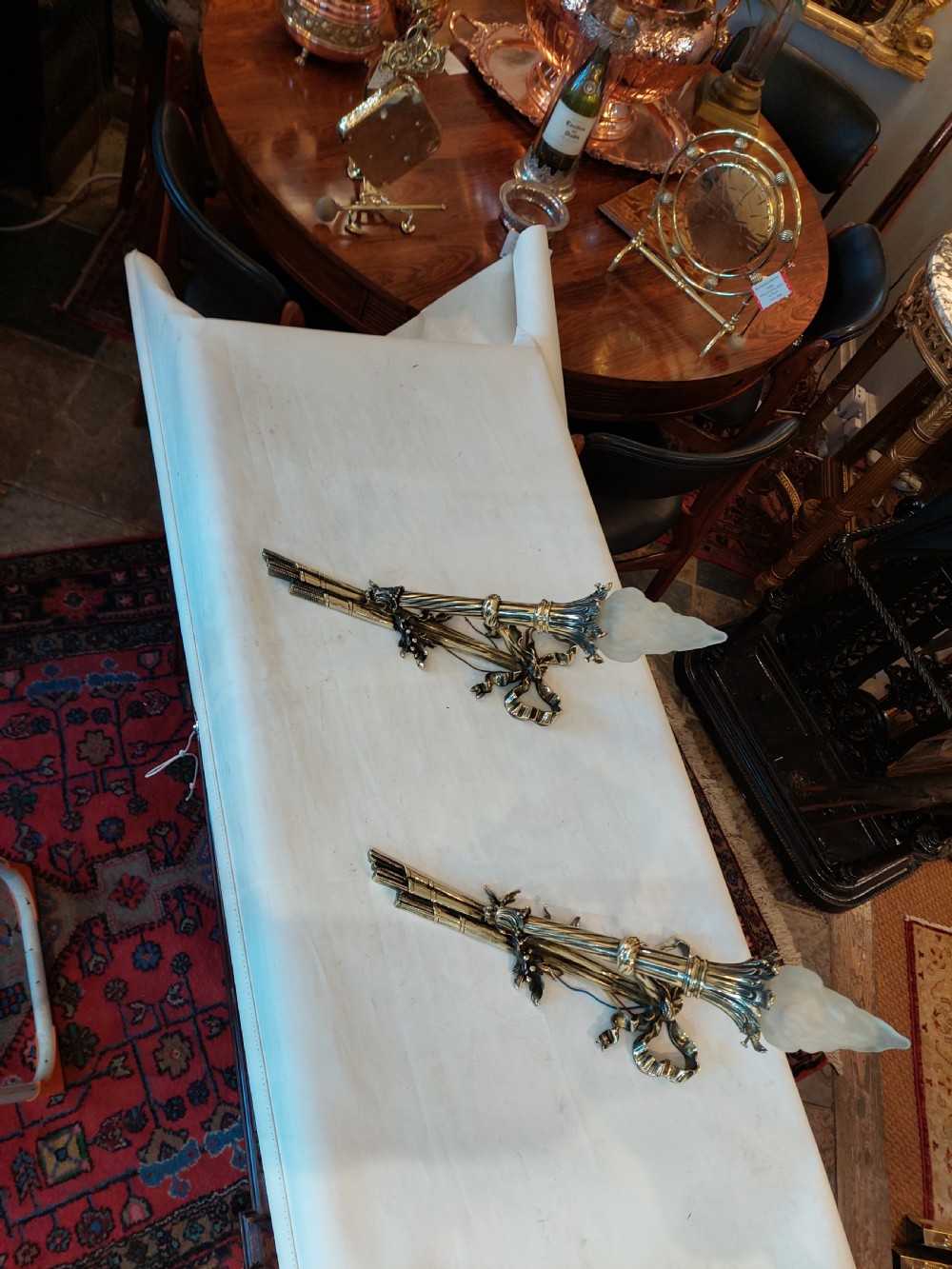 A pair of early twentieth-century Neoclassical brass wall sconces shaped as torches with ribbon bow details and frosted flame glass shades. View III