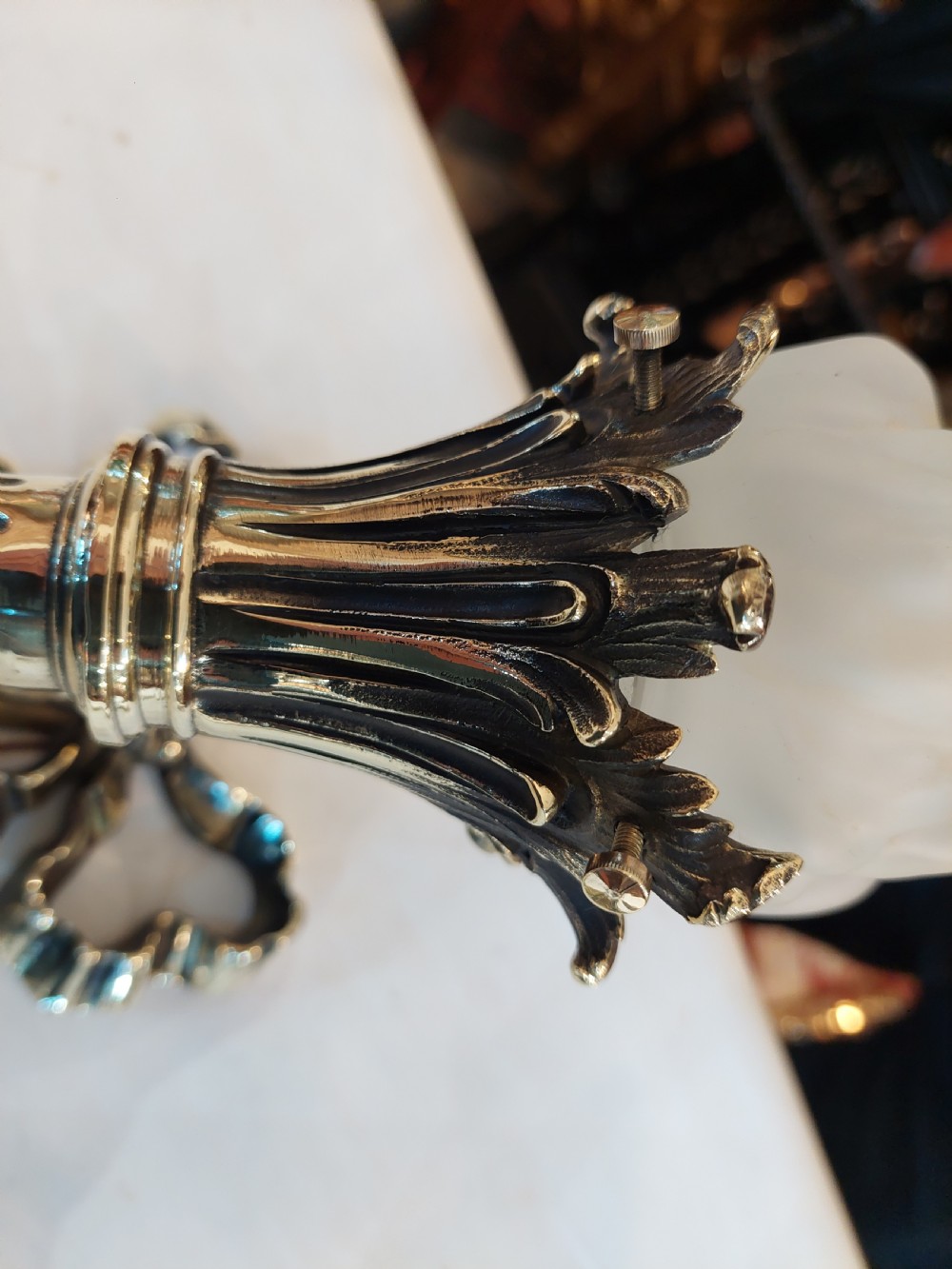 A pair of early twentieth-century Neoclassical brass wall sconces shaped as torches with ribbon bow details and frosted flame glass shades. View IV
