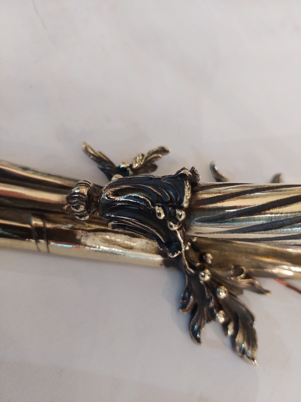 A pair of early twentieth-century Neoclassical brass wall sconces shaped as torches with ribbon bow details and frosted flame glass shades. View V