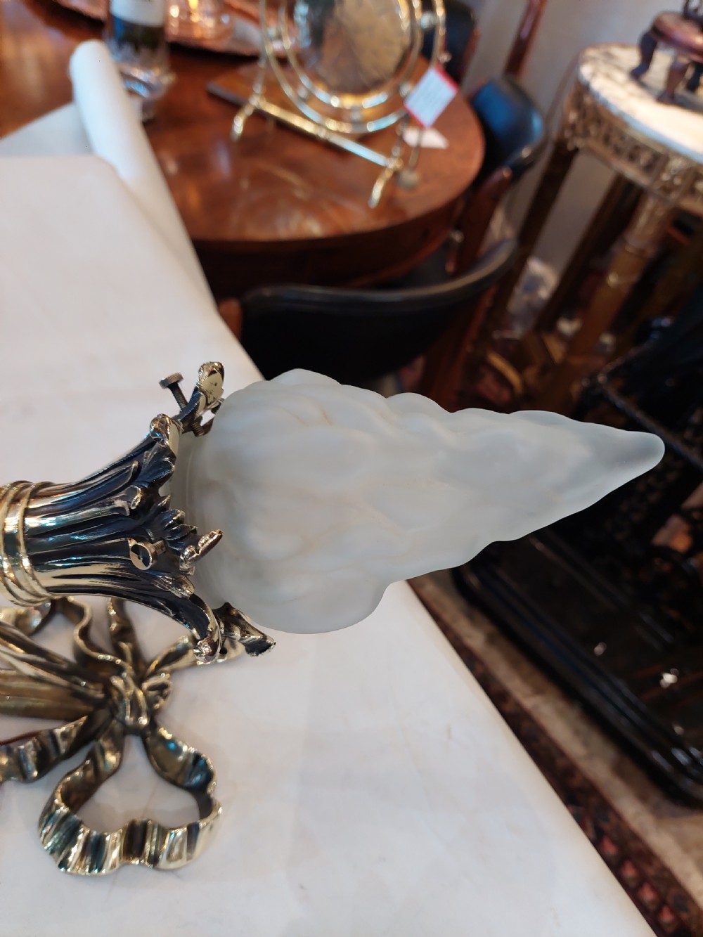 A pair of early twentieth-century Neoclassical brass wall sconces shaped as torches with ribbon bow details and frosted flame glass shades. View VII