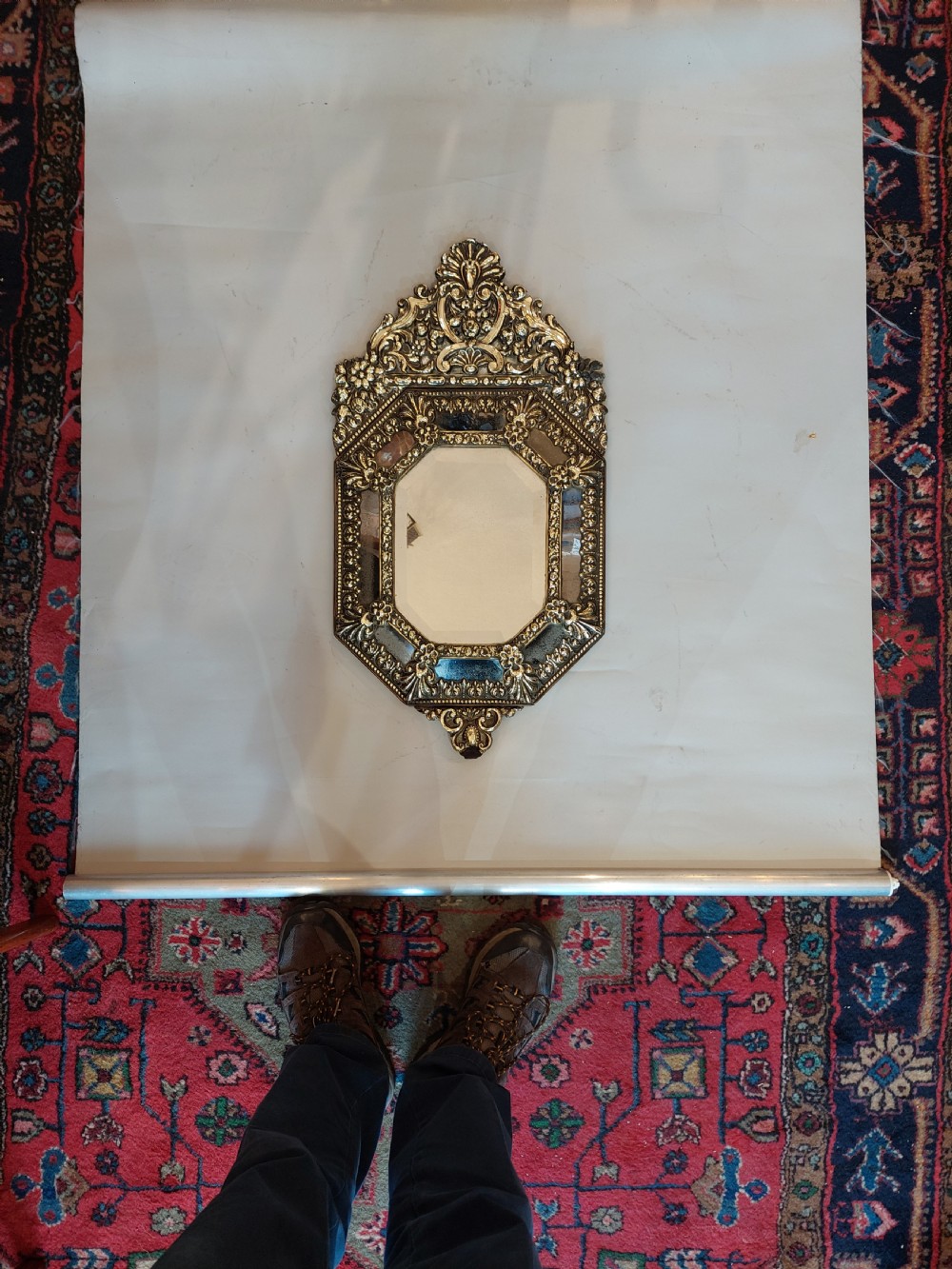 An antique Victorian octagonal cushion mirror featuring an embossed brass frame with floral cresting and mirrored border sections. View VI