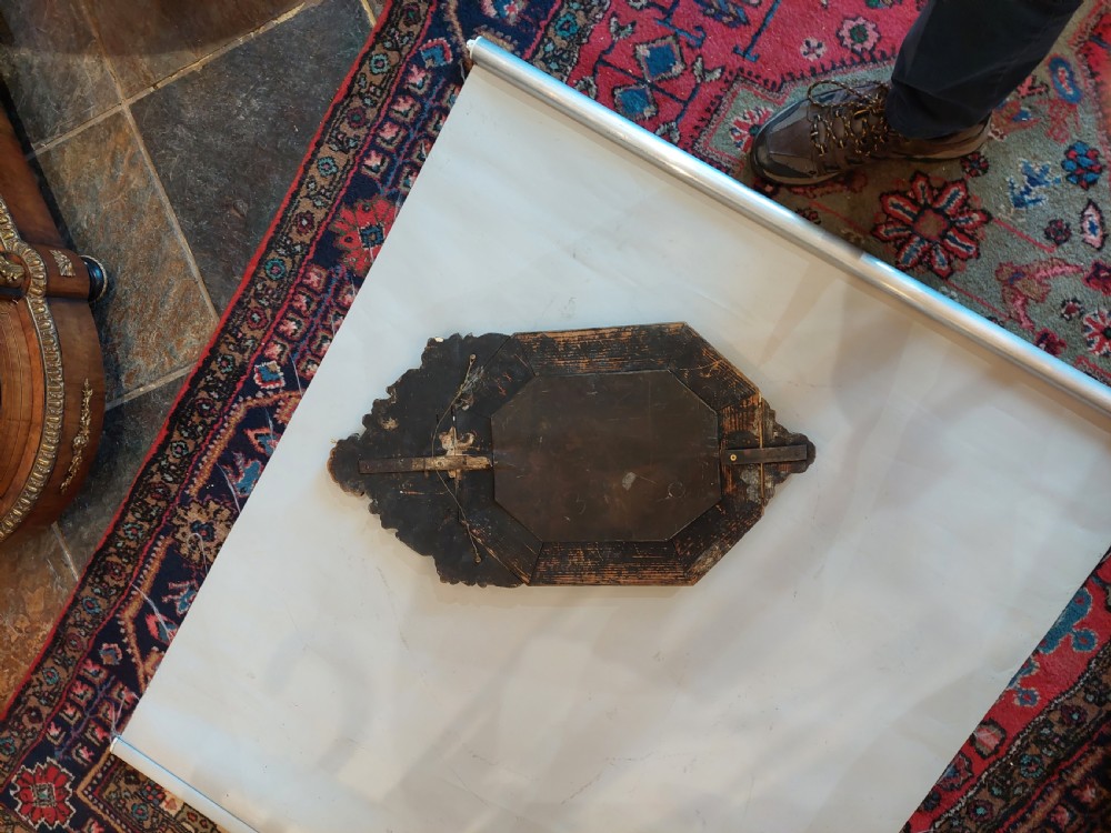 An antique Victorian octagonal cushion mirror featuring an embossed brass frame with floral cresting and mirrored border sections. View IX
