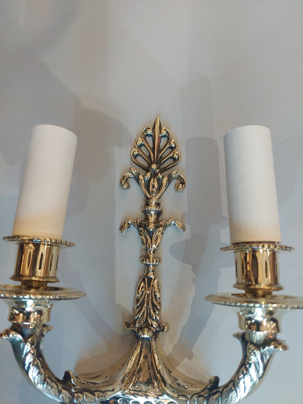 A set of four early 20th-century gilt brass twin-arm wall sconces featuring Neoclassical urn and anthemion motifs. View IV