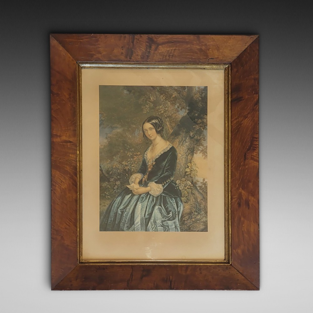 A framed 19th-century colour print depicting a seated woman in a dark green dress holding a letter, set within a wide timber veneer frame with a gilt inner slip.