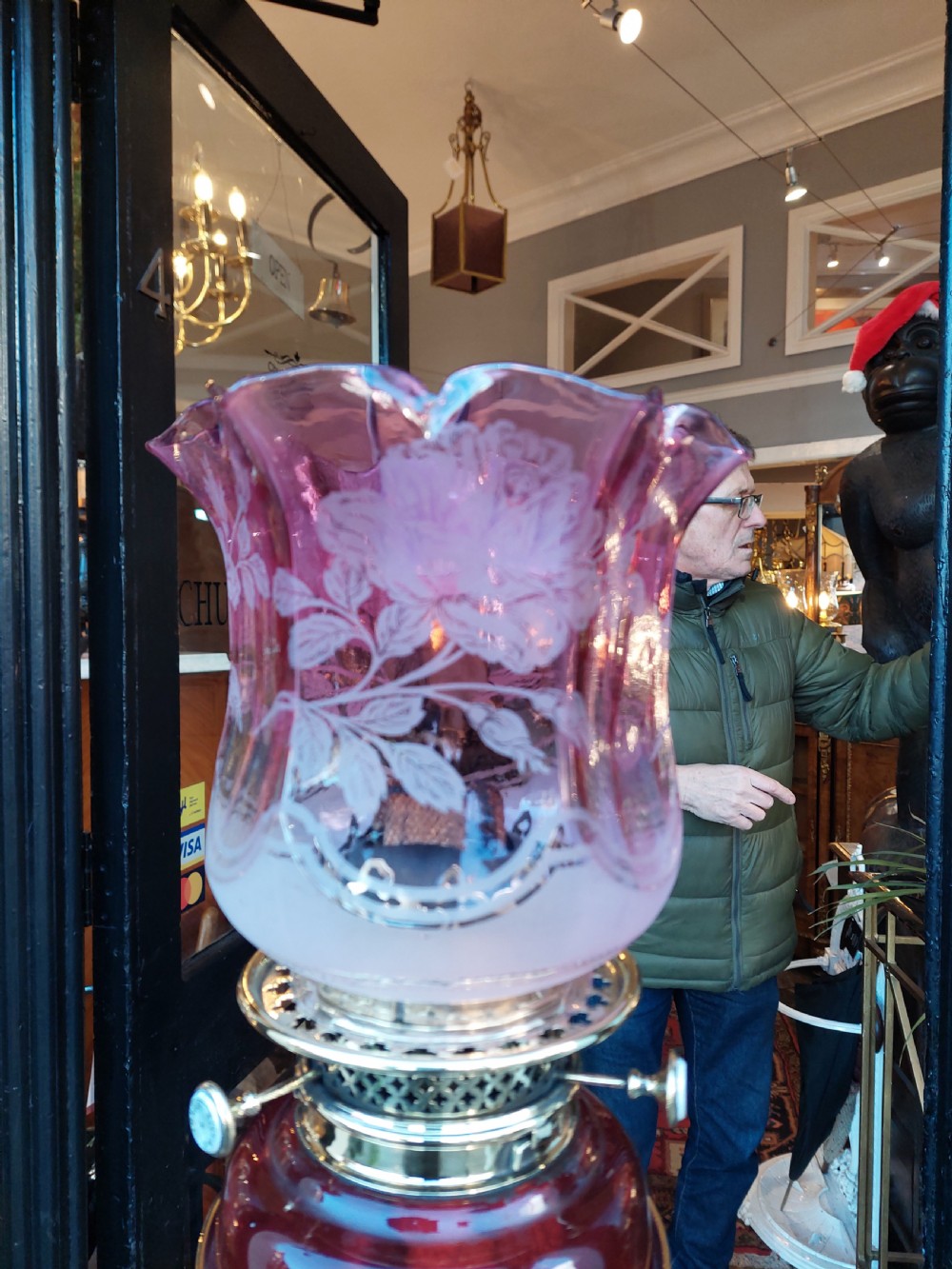 A late 19th-century brass and copper floor-standing oil lamp featuring claw feet and a cranberry glass font and shade. View VI