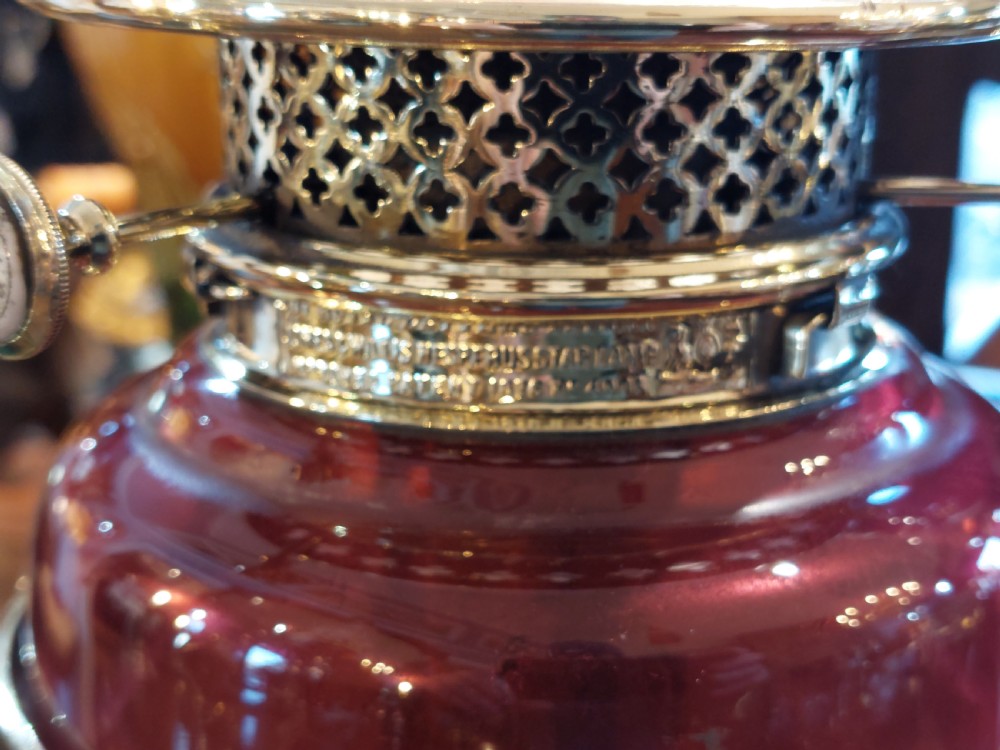 A late 19th-century brass and copper floor-standing oil lamp featuring claw feet and a cranberry glass font and shade. View VIII