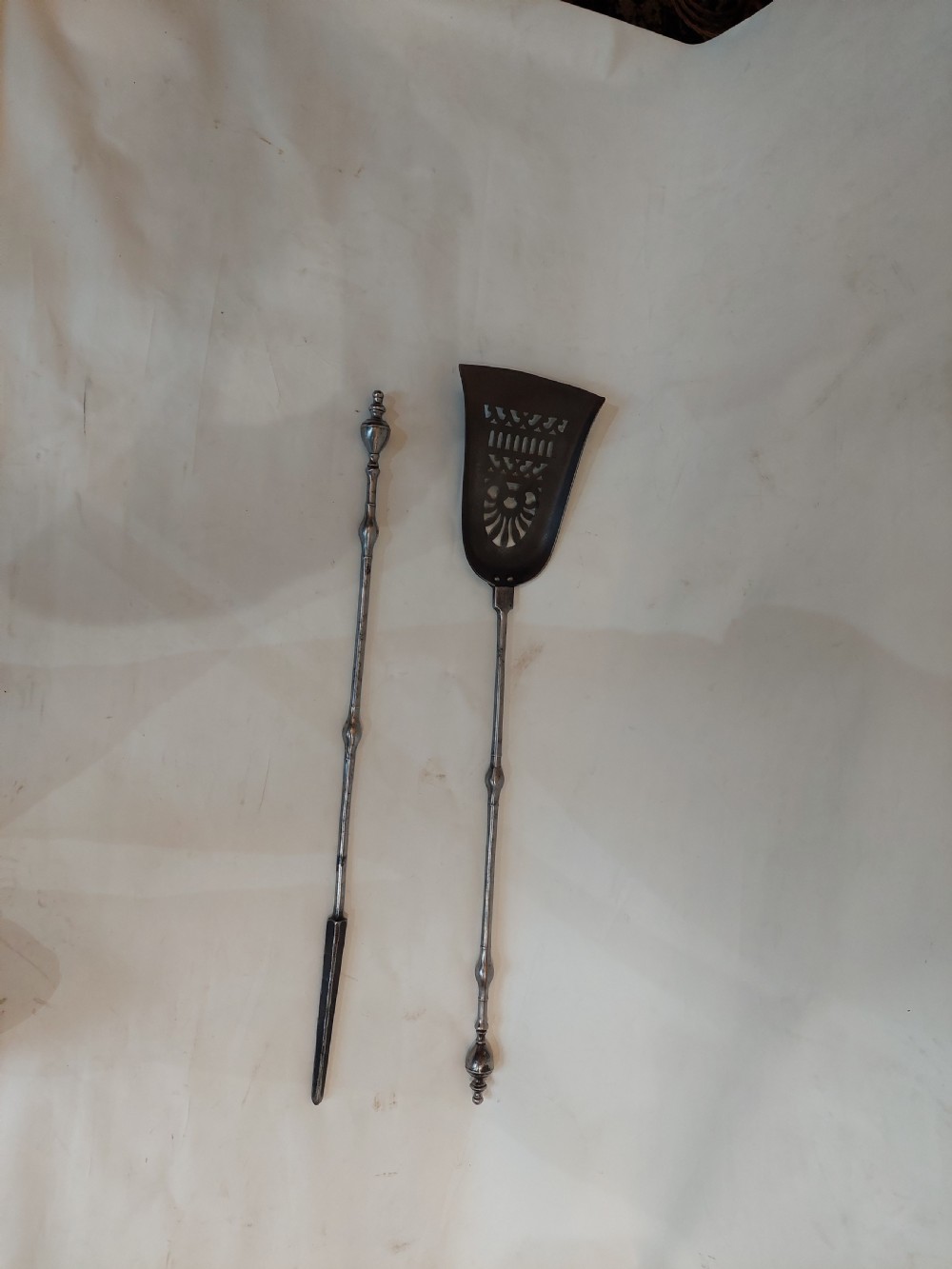 A pair of Georgian steel fire tools consisting of a poker and a shovel with a pierced decorative blade. View II