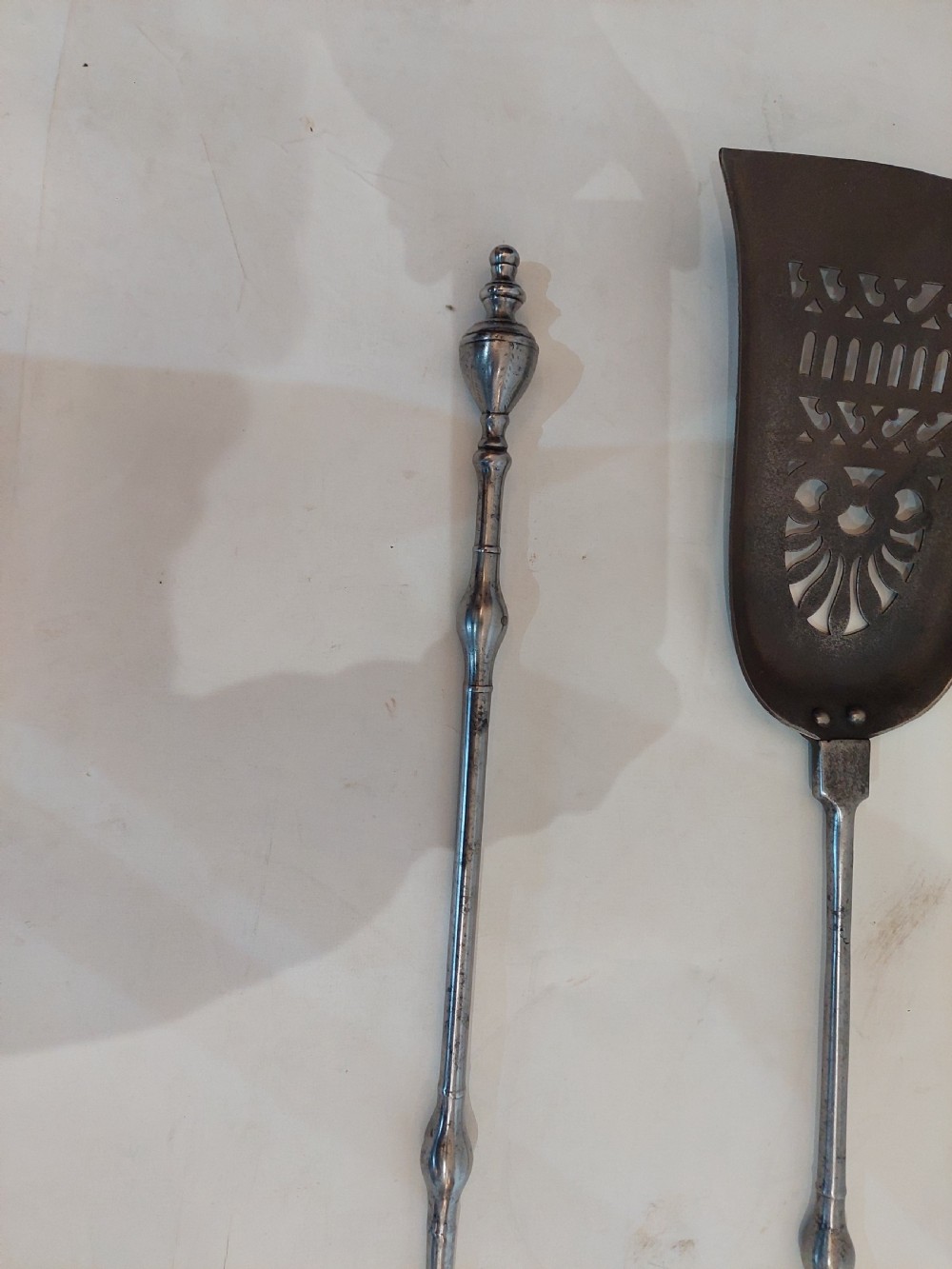 A pair of Georgian steel fire tools consisting of a poker and a shovel with a pierced decorative blade. View VI