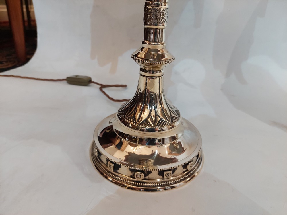 A pair of 19th-century Gothic Revival cast brass table lamps featuring knopped columns and dome-shaped green patterned fabric shades with long fringe and tassels. View II