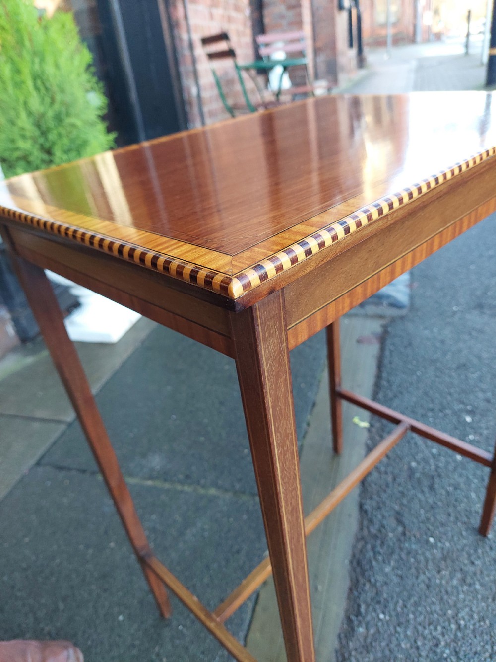An Edwardian rectangular mahogany occasional table featuring geometric inlaid border decoration and slender square tapered legs. View IV