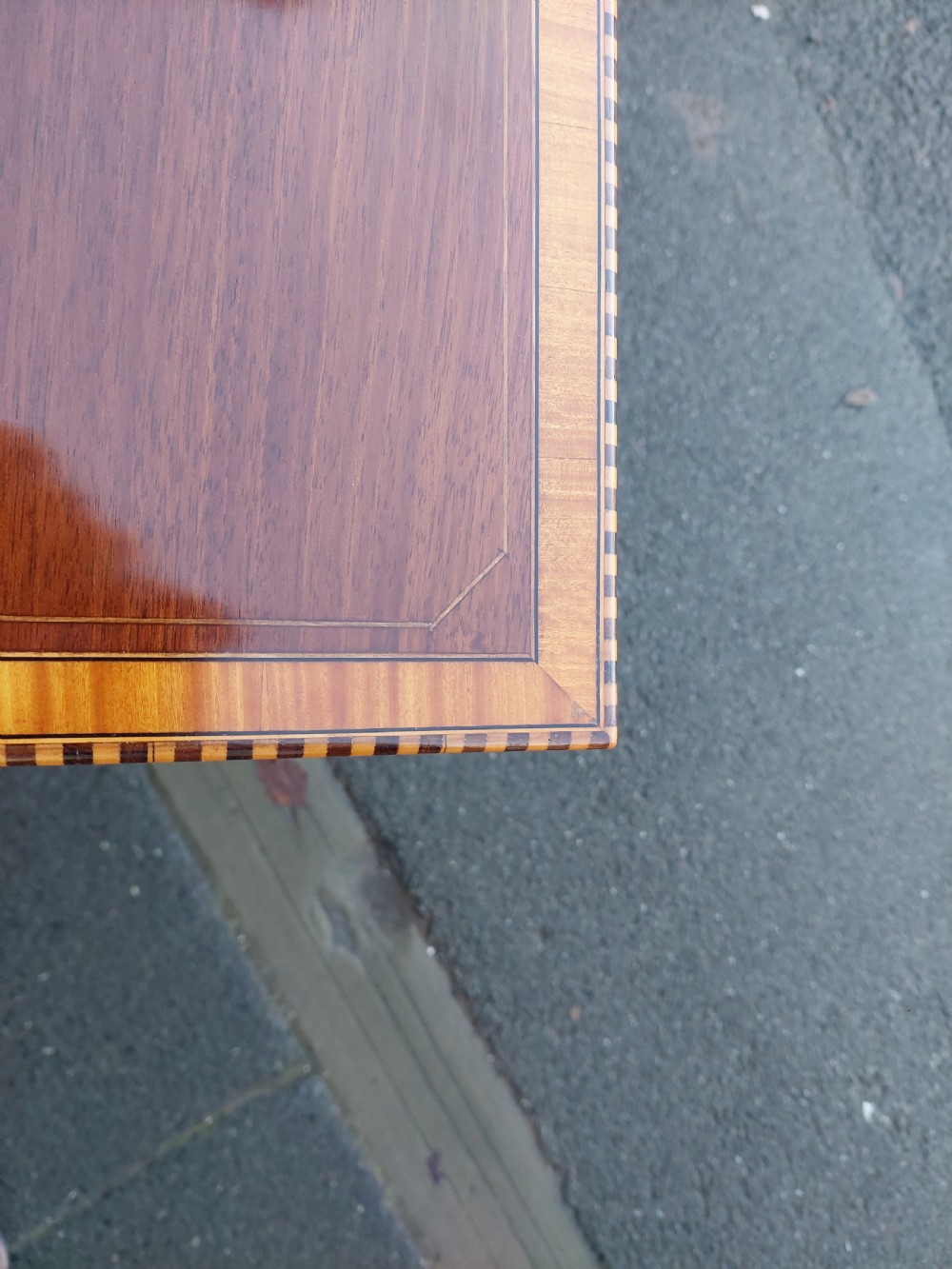 An Edwardian rectangular mahogany occasional table featuring geometric inlaid border decoration and slender square tapered legs. View V