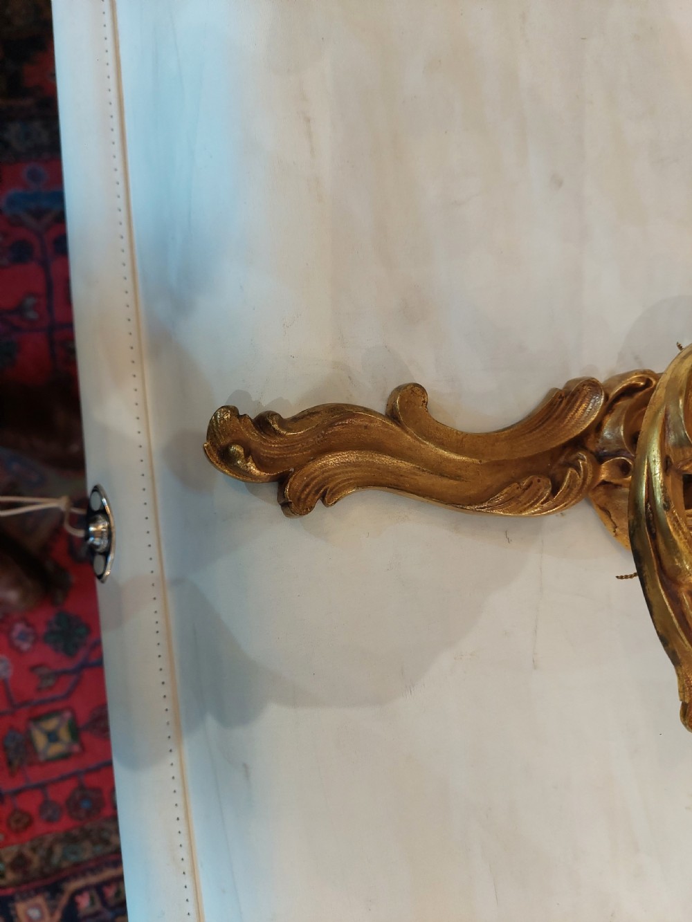 Set of four early twentieth-century cast brass two-arm wall lights featuring ornate Rococo scrolling foliage backplates and candle sockets. View III