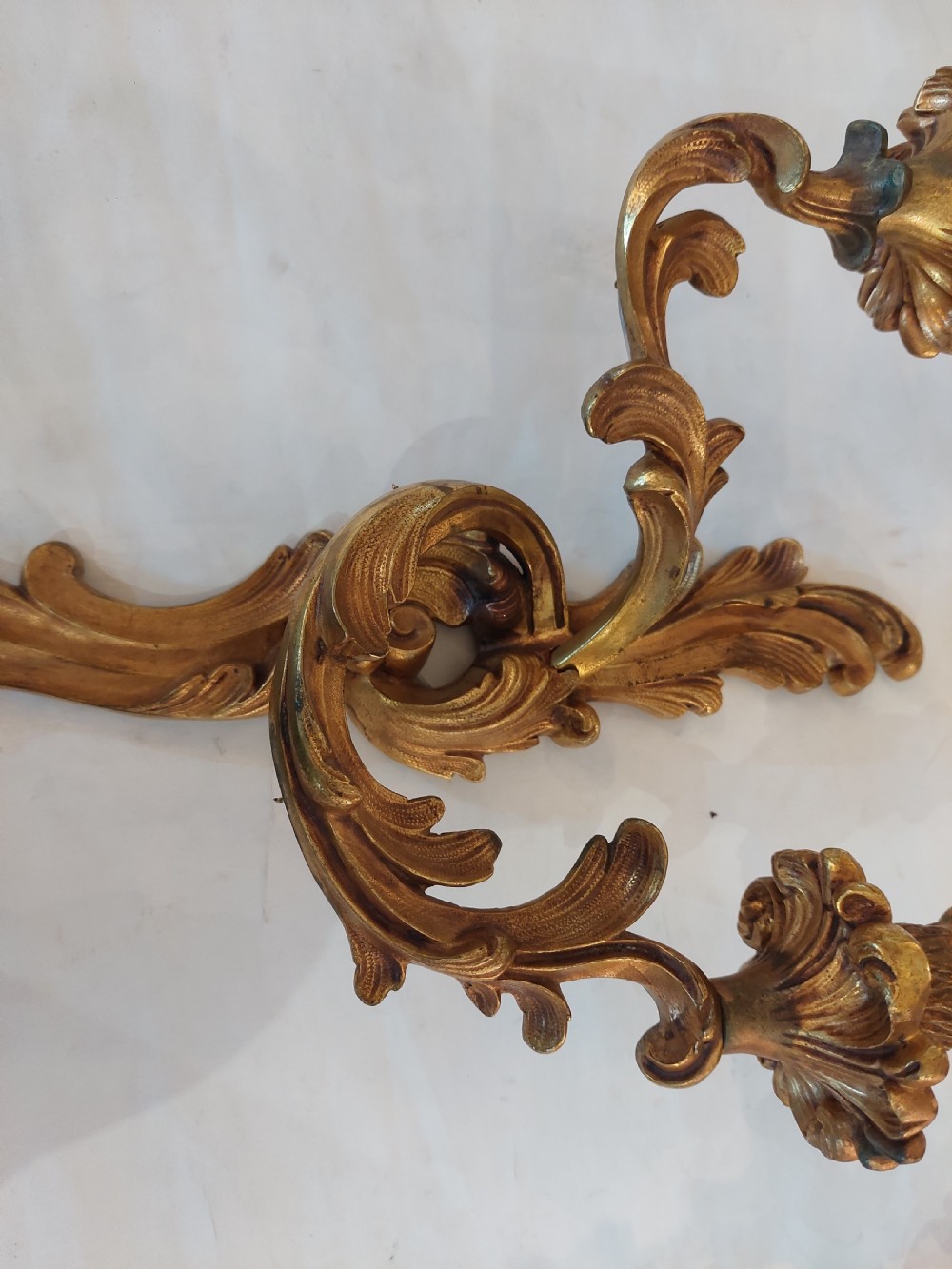 Set of four early twentieth-century cast brass two-arm wall lights featuring ornate Rococo scrolling foliage backplates and candle sockets. View V