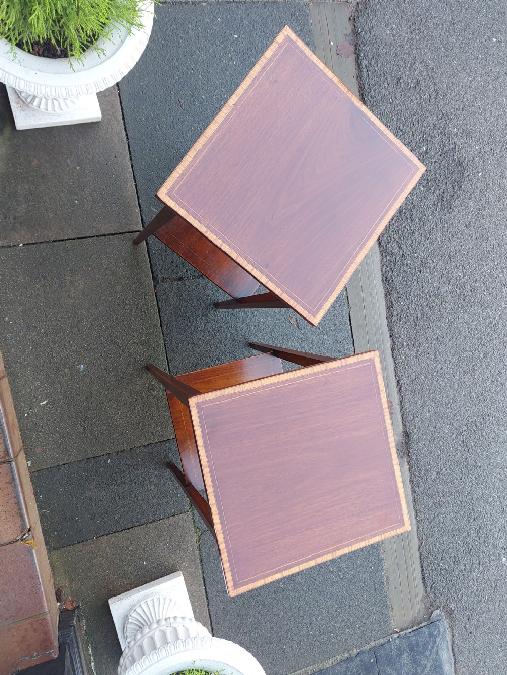 A pair of tall, slim Edwardian mahogany side tables featuring square tops with light wood inlaid borders, square tapered legs, and lower shelf tiers. View II