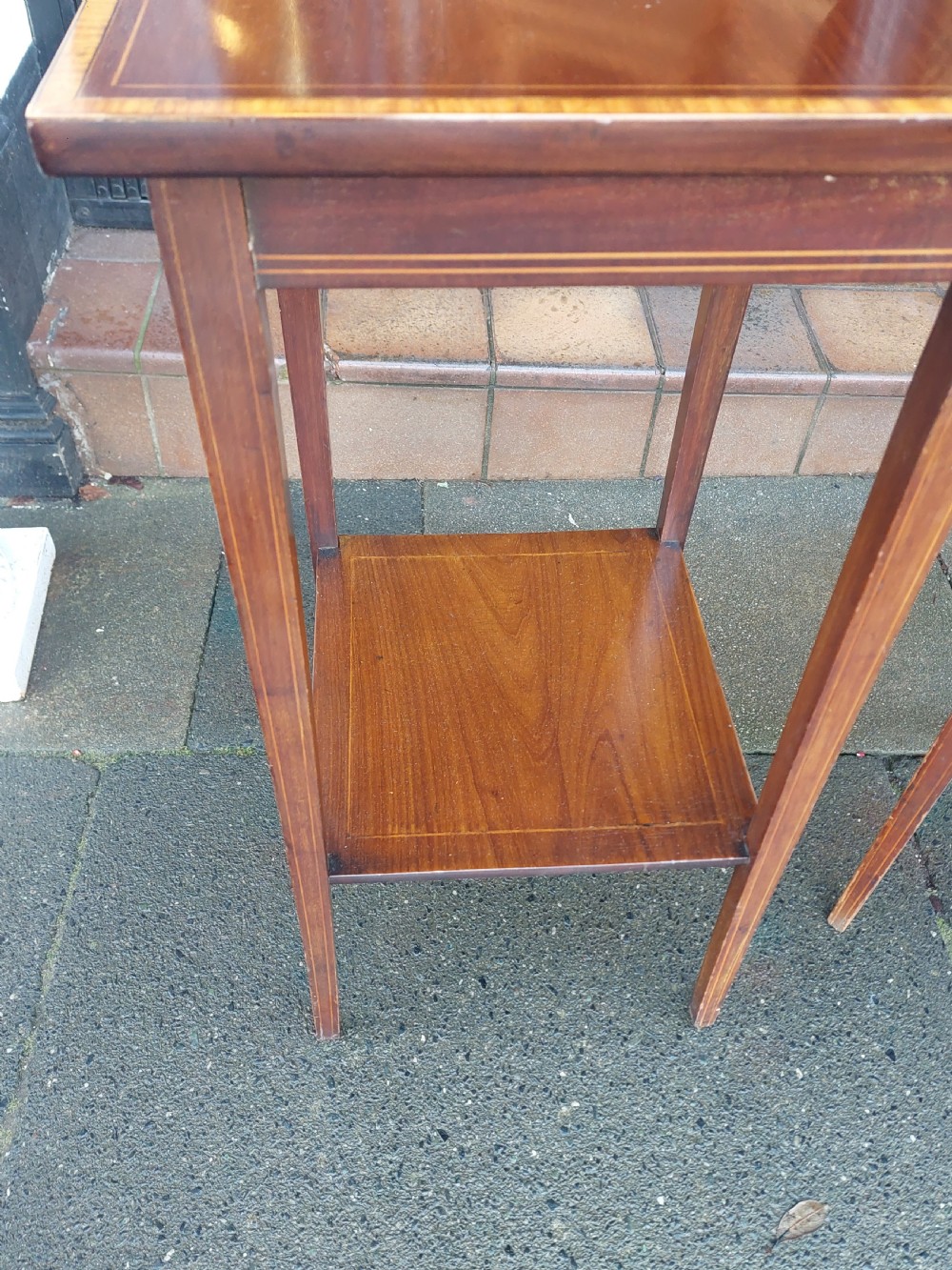 A pair of tall, slim Edwardian mahogany side tables featuring square tops with light wood inlaid borders, square tapered legs, and lower shelf tiers. View III