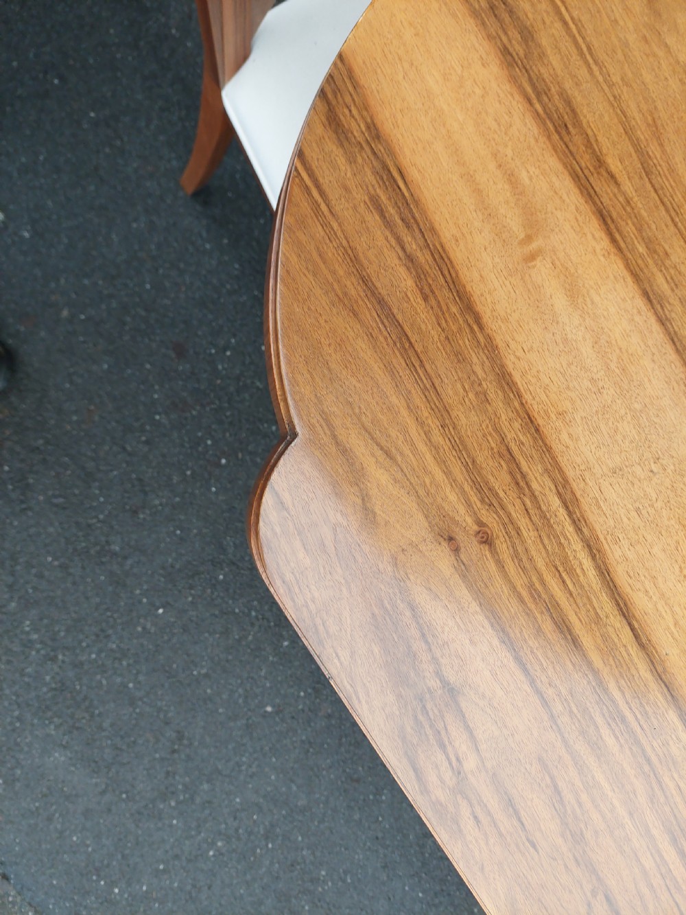 An Art Deco walnut dining suite comprising an oval pedestal table and six matching chairs with arched burr walnut backs and cream upholstered seats. View VIII