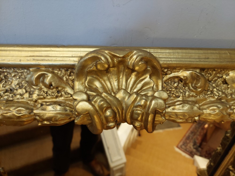 A rectangular 19th-century giltwood wall mirror featuring an ornate carved frame with sand-moulded gesso texture and scrolling foliage details. View IV