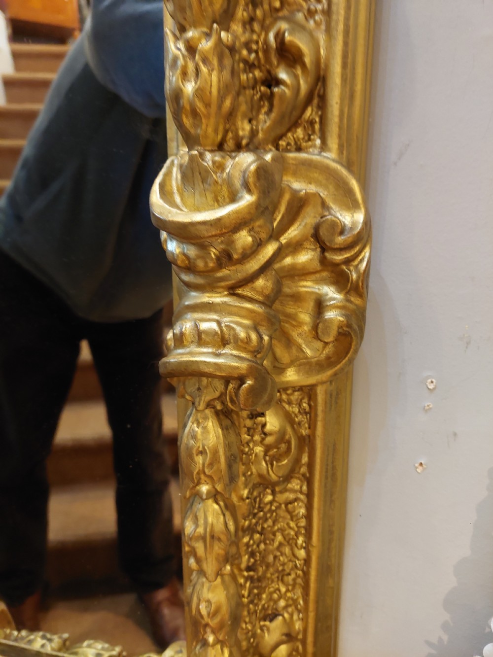 A rectangular 19th-century giltwood wall mirror featuring an ornate carved frame with sand-moulded gesso texture and scrolling foliage details. View VI