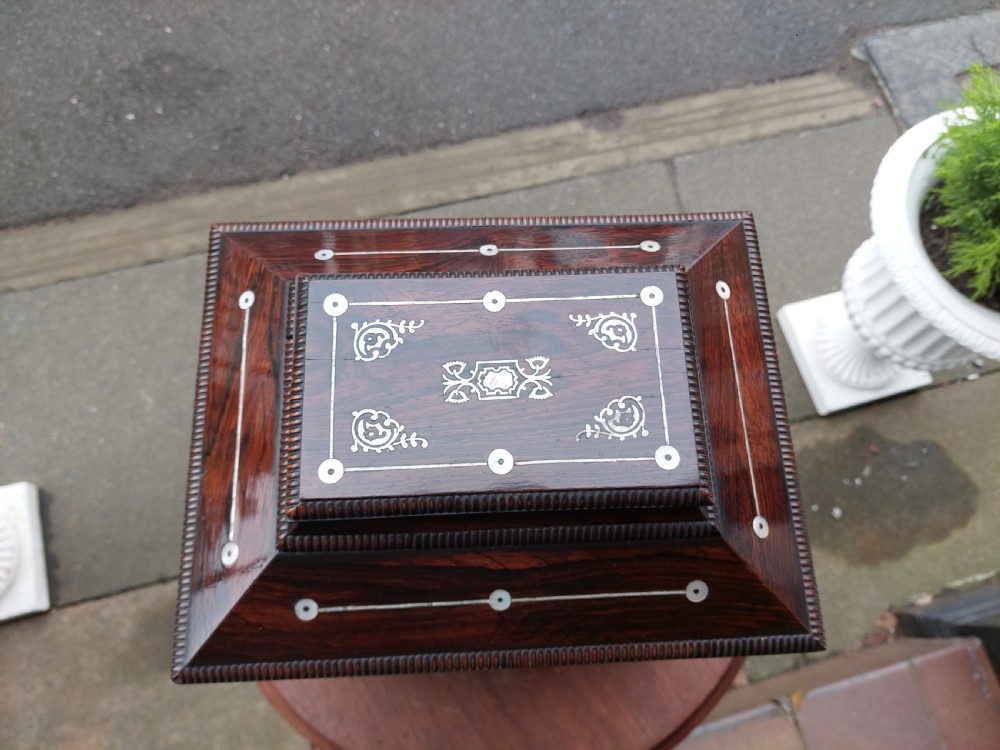 A nineteenth-century dark rosewood jewellery cabinet featuring mother-of-pearl decorative inlay, two front doors, a stepped lid, and turned feet. View IV