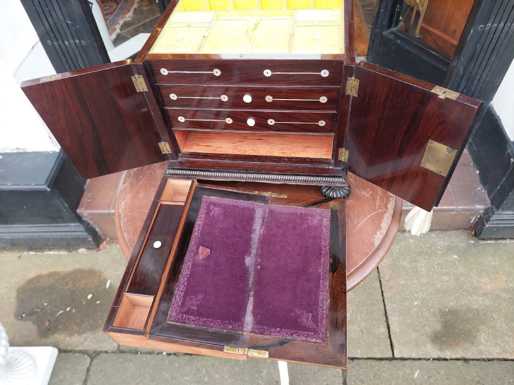 A nineteenth-century dark rosewood jewellery cabinet featuring mother-of-pearl decorative inlay, two front doors, a stepped lid, and turned feet. View X