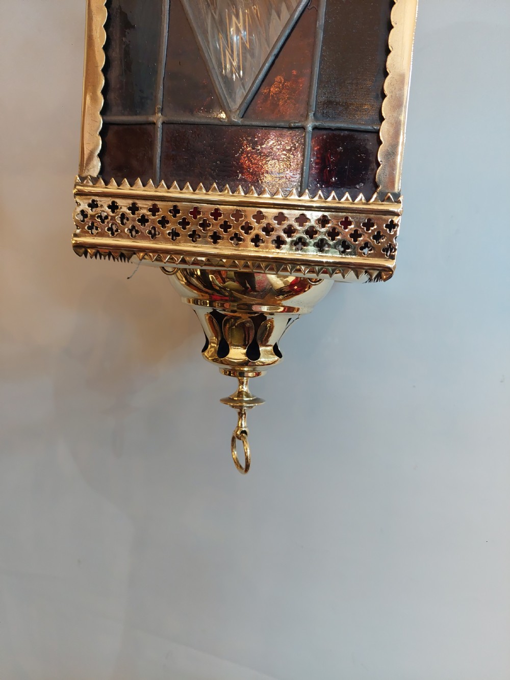 A Victorian hanging brass lantern with rectangular leaded glass panels displaying diamond motifs and suspended by delicate chains. View III