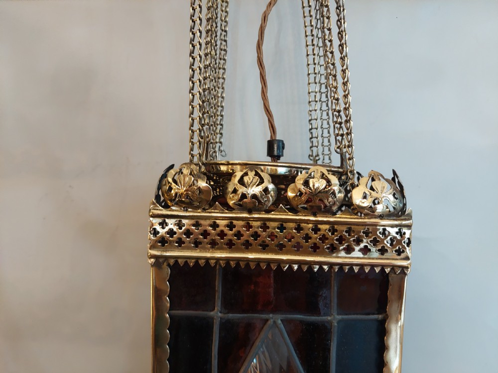 A Victorian hanging brass lantern with rectangular leaded glass panels displaying diamond motifs and suspended by delicate chains. View V